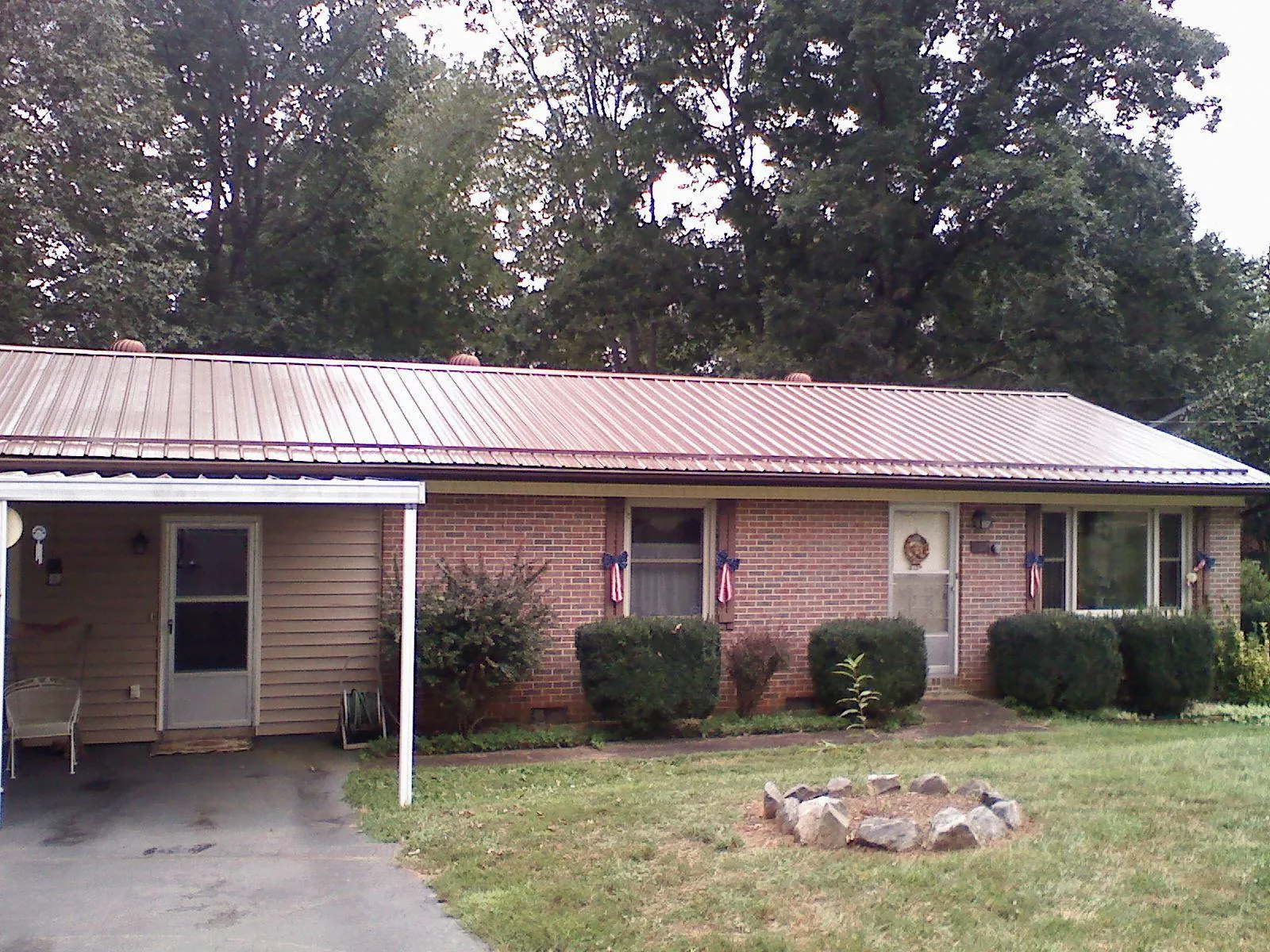 Bronze metal roof and carport on a brick ranch home — Roof Repair work by our crew in Belden